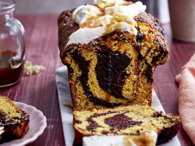 Kürbis-Kakao-Kuchen auf einem grauen Servierteller, auf dunkelrotem Hintergrund.  | © EAT CLUB/Isabell Triemer