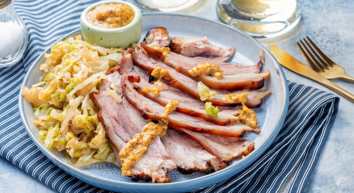 Bayrisch Kraut mit kaltem Braten in Scheiben geschnitten und Senf / Senf / alles auf rundem Teller / Messer und Gabel / Glas Wasser / Untergrund Tuch und Tischplatte
