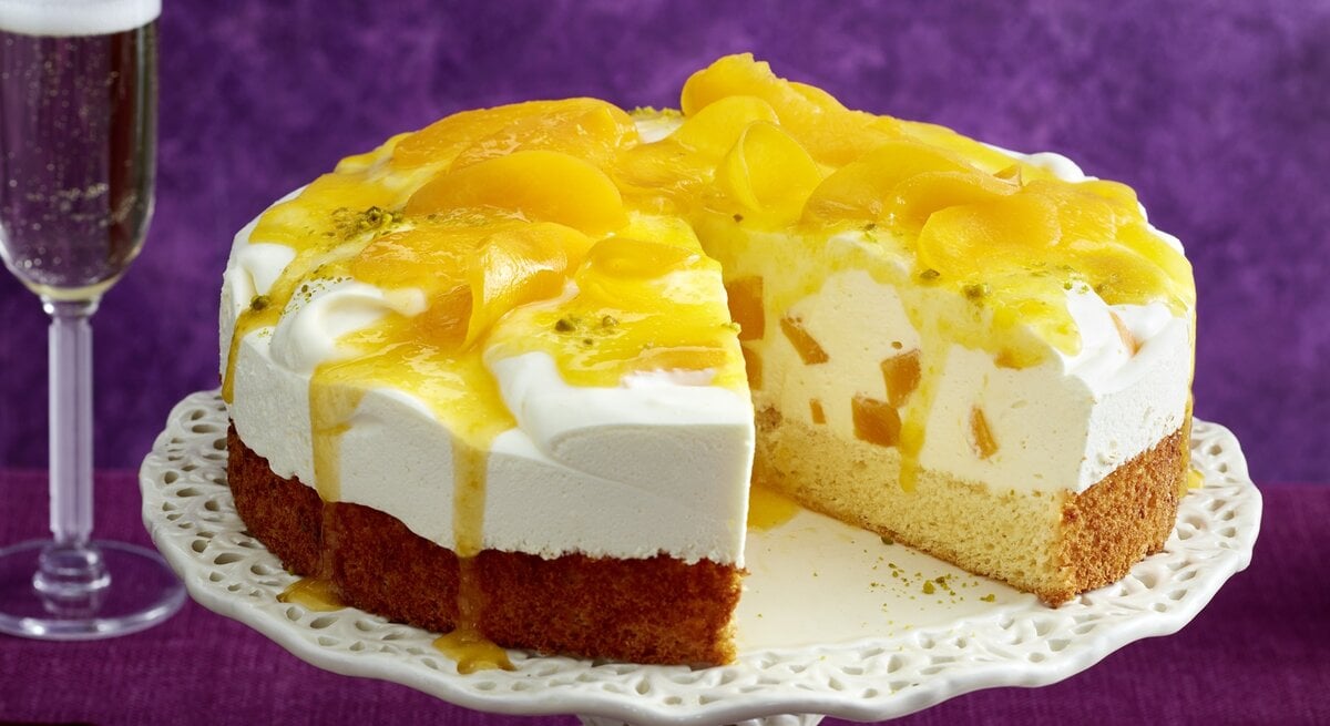 Bellini-Quark-Torte mit Pfirsich / runde Tortenplatte / Draufsicht, schräg