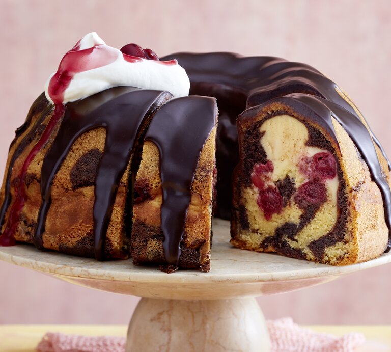 Der Gugelhupf auf einem Tortenständer mit rosa Hintergrund. | © EAT CLUB/ Isabell Triemer