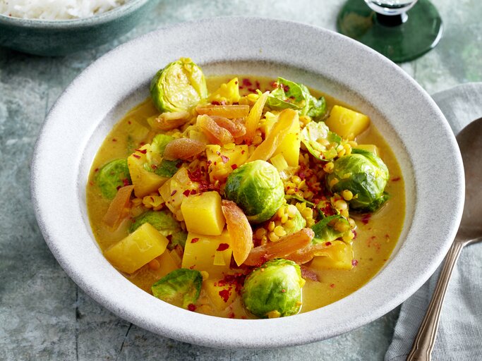 Rosenkohl-Steckrüben-Curry in einer weißen Schüssel auf grauem Hintergrund. | © EAT CLUB/Isabell Triemer