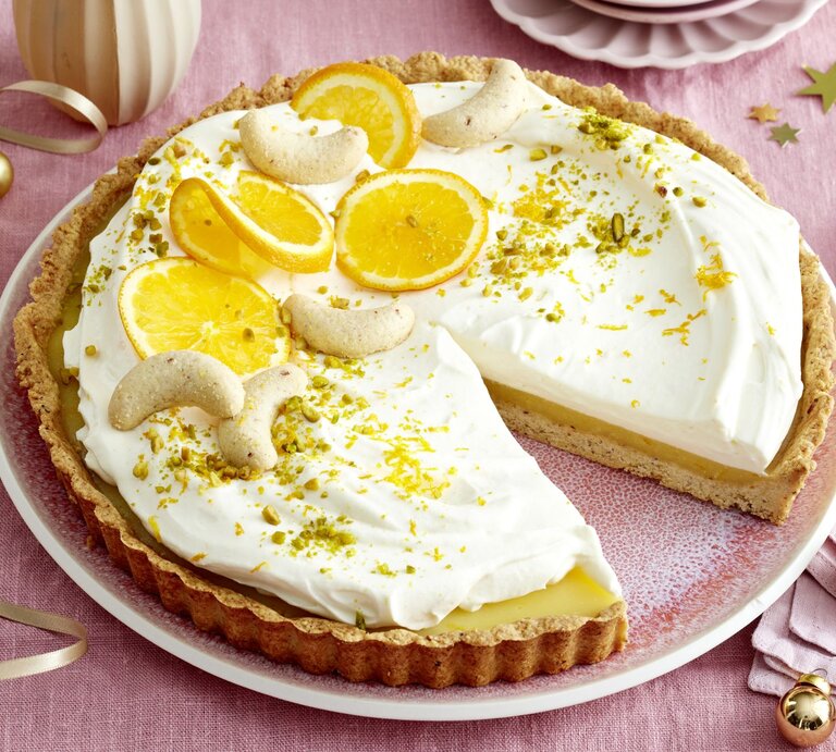Orangen-Nuss-Tarte mit Sahnecreme, Orangenscheiben und Nüssen auf einer Tortenplatte. | © EAT CLUB/Isabell Triemer