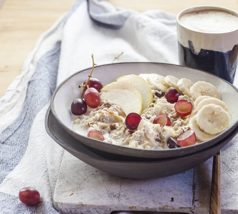 Bircher Müsli mit Haferflocken, Banane, Trauben und Apfelscheiben in einer Schale. | © Getty Images/Westend61