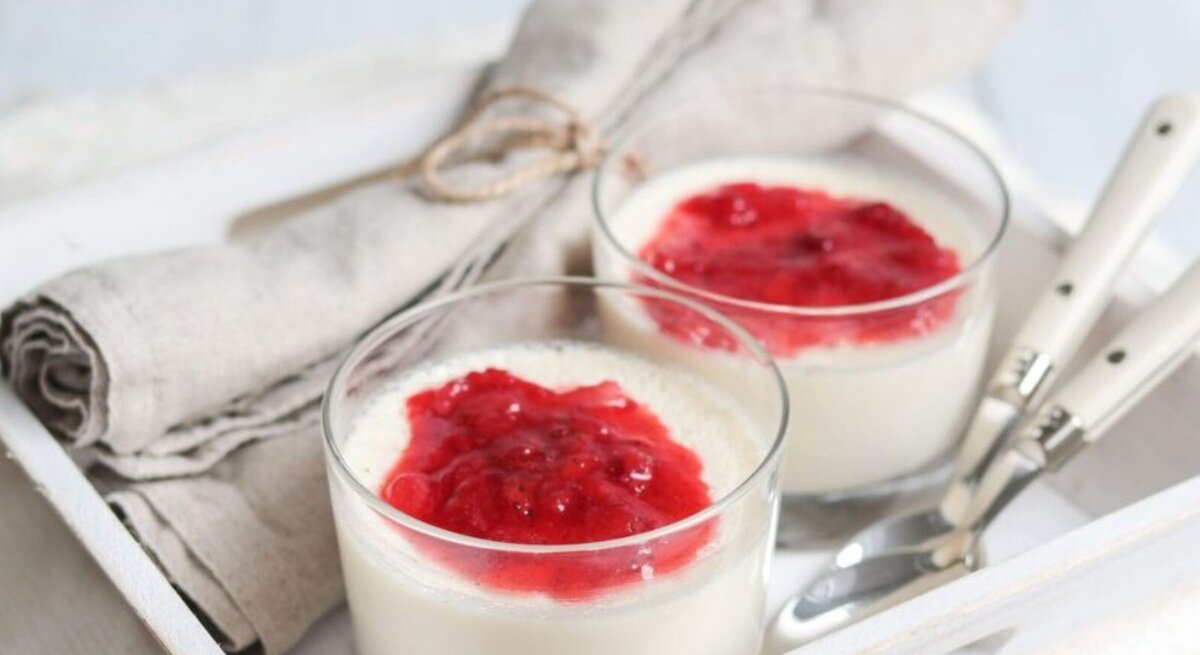  Panna Cotta in Gläsern mit Erdbeersauce, serviert auf einem Tablett.