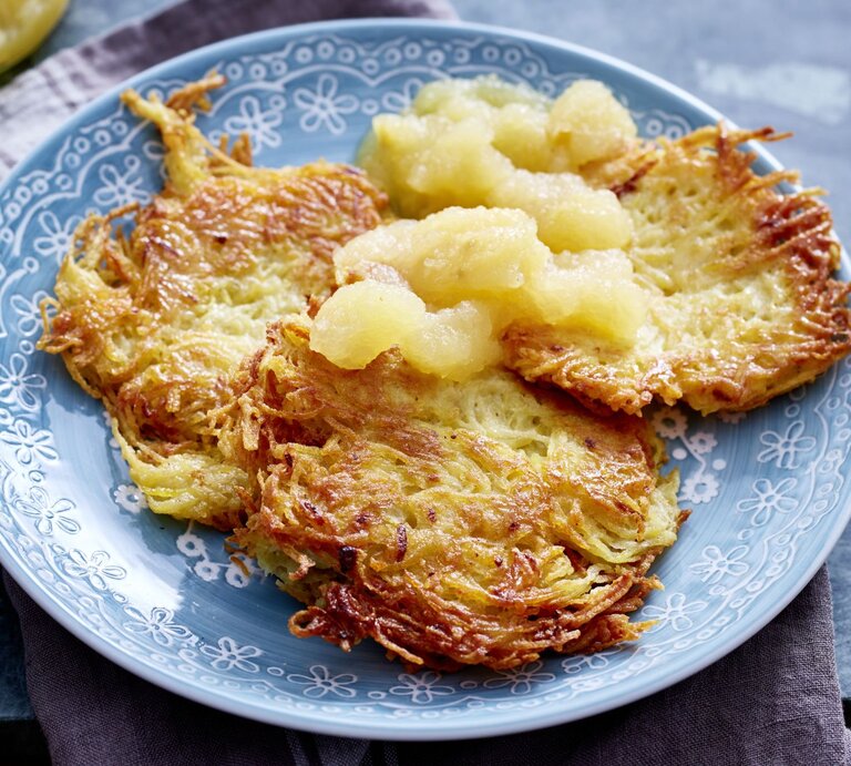 Goldbraun gebratene Kartoffelpuffer auf einem Teller mit Apfelmus. | © EAT CLUB/Isabell Triemer