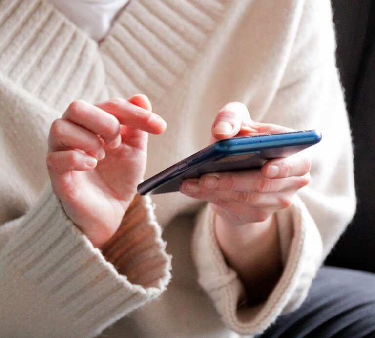 Zu sehen ist eine Frau, die ein Handy hält | © GettyImages/Kinga Krzeminska