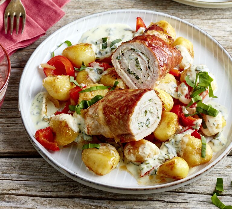 Bärlauch-Schnitzelröllchen auf einem weißen Teller auf hölzernem Hintergrund.  | © EAT CLUB/Isabell Triemer