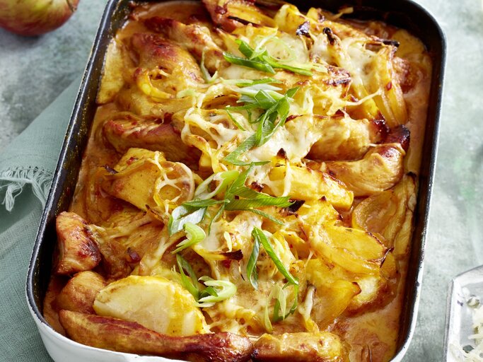 Puten-Curry-Auflauf in einer weißen Auflaufform auf grauem Hintergrund.  | © EAT CLUB/Isabell Triemer