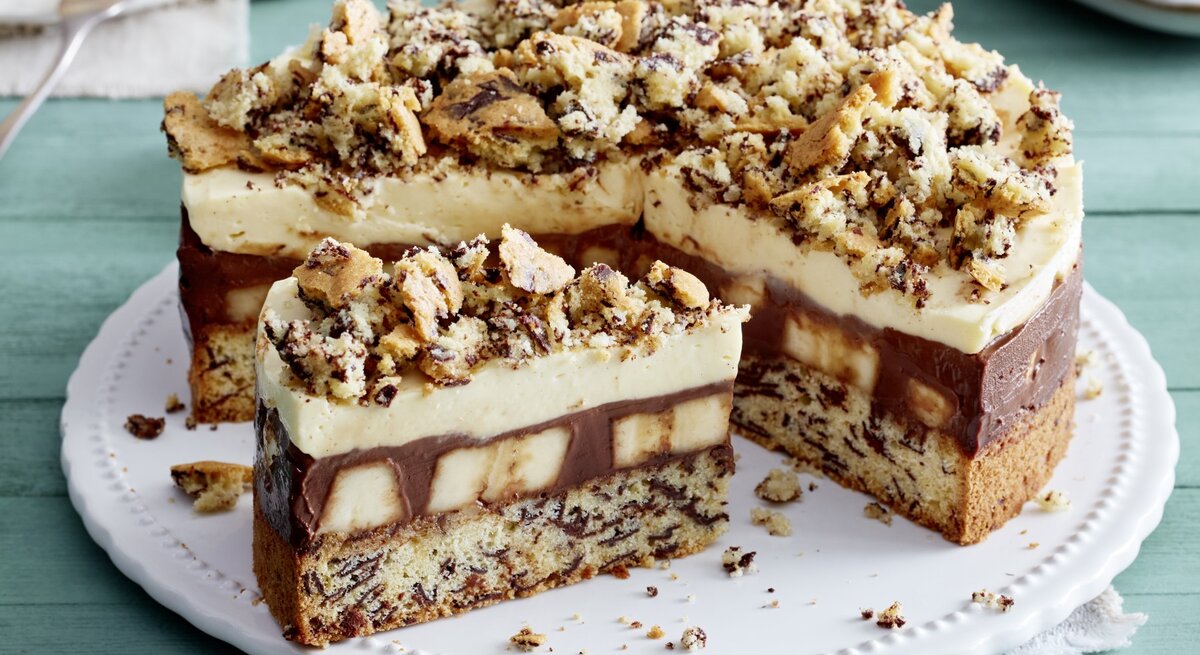 Schoko-Bananen-Torte auf einem weißen Tortenteller auf grünem Hintergrund. 