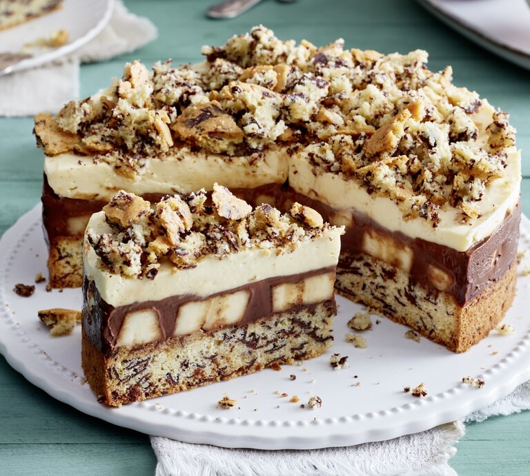 Schoko-Bananen-Torte auf einem weißen Tortenteller auf grünem Hintergrund.  | © EAT CLUB / Isabell Triemer