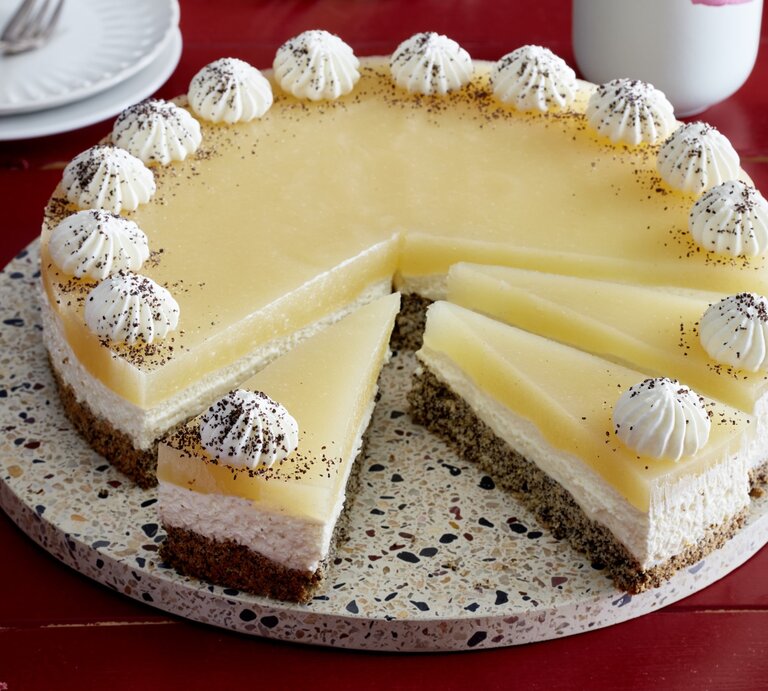 Birnen-Mohn-Torte auf einem Tortenteller auf rotem Hintergrund. | © EAT CLUB/Isabell Triemer