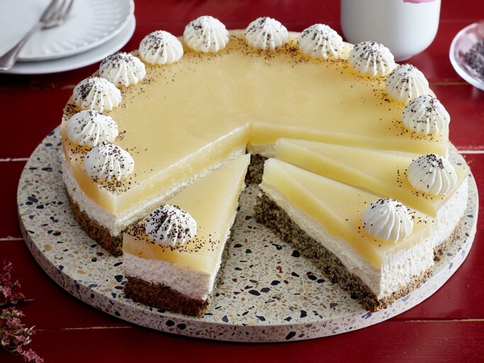 Birnen-Mohn-Torte auf einem Tortenteller auf rotem Hintergrund. | © EAT CLUB/Isabell Triemer