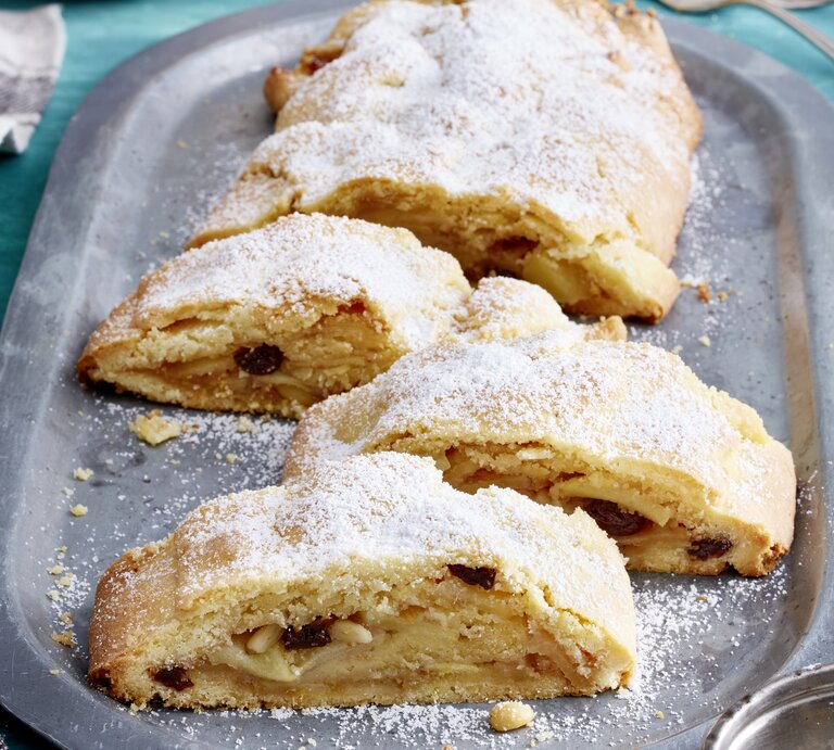 Südtiroler Apfelstrudel auf einem silbernen Servierteller auf blauem Hintergrund.  | © EAT CLUB / Isabell Triemer
