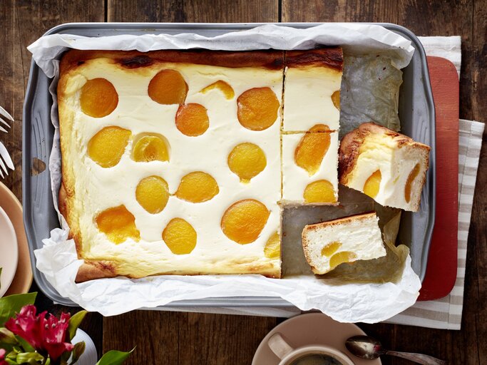 Aprikosen-Käsekuchen in einem Backblech auf hölzernem Hintergrund.  | © EAT CLUB/Isabell Triemer
