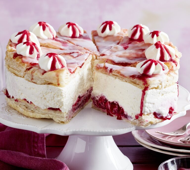 Holländischer Kirschkuchen auf einem weißen Tortenteller vor rosarotem Hintergrund.  | © EAT CLUB/Isabell Triemer
