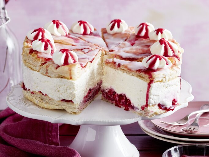 Holländischer Kirschkuchen auf einem weißen Tortenteller vor rosarotem Hintergrund.  | © EAT CLUB/Isabell Triemer