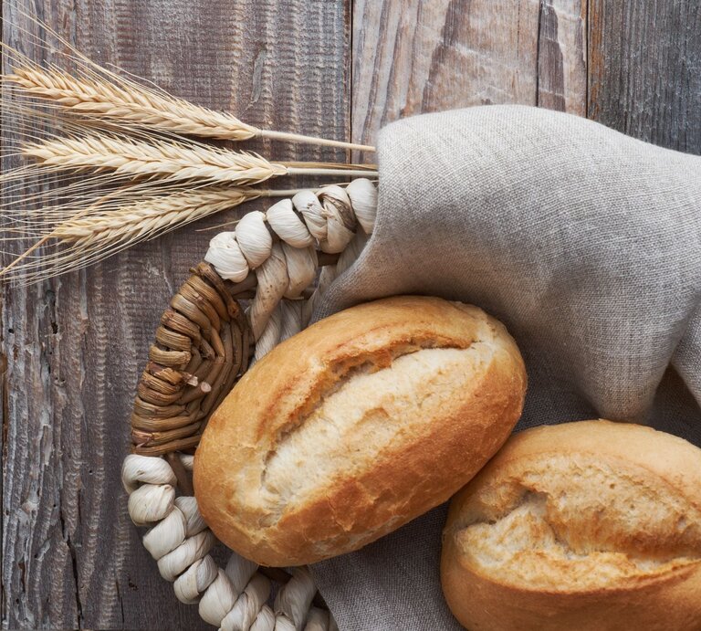 Zwei Brötchen im Brotkorb auf graubraunem Holz.  | © AdobeStock/tilialucida
