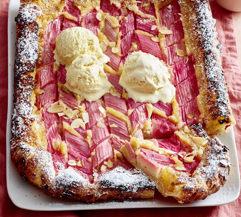Rhabarber-Mandel-Galette auf einem weißen Teller auf rosa Hintergrund.  | © EAT CLUB/Isabell Triemer
