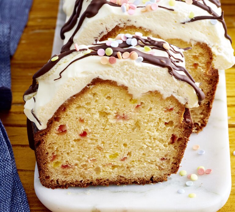 Funfetti-Kuchen mit Schwips auf einem weißen Teller auf hölzernem Hintergrund.  | © EAT CLUB/Isabell Triemer