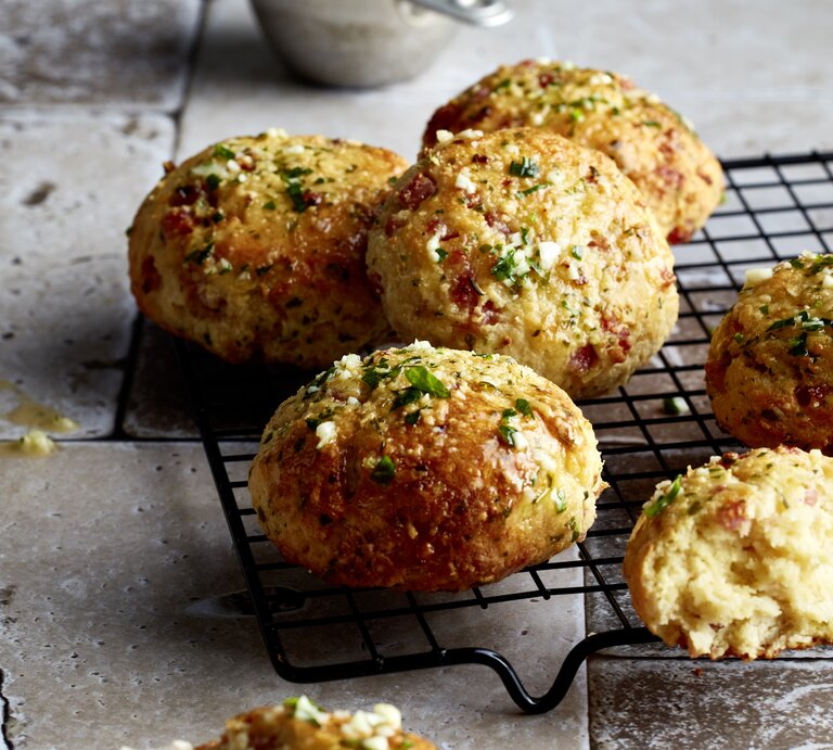 Triple-Cheese-Brötchen aus der Pfanne auf einem schwarzen Gitter auf grauem Hintergrund.  | © EAT CLUB / Isabell Triemer
