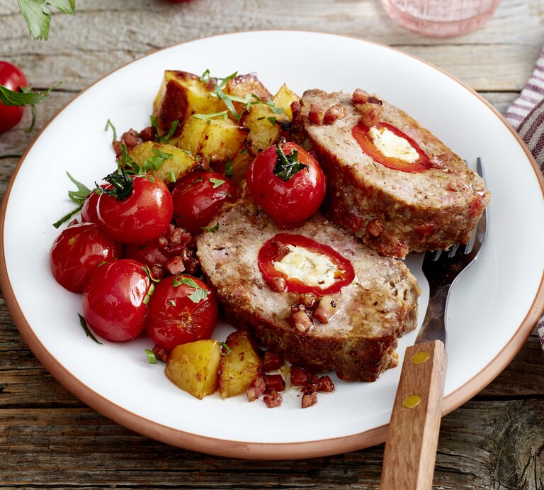 Holzfäller-Braten auf einem weißen Teller auf hölzernem Hintergrund. | © EAT CLUB / Isabell Triemer