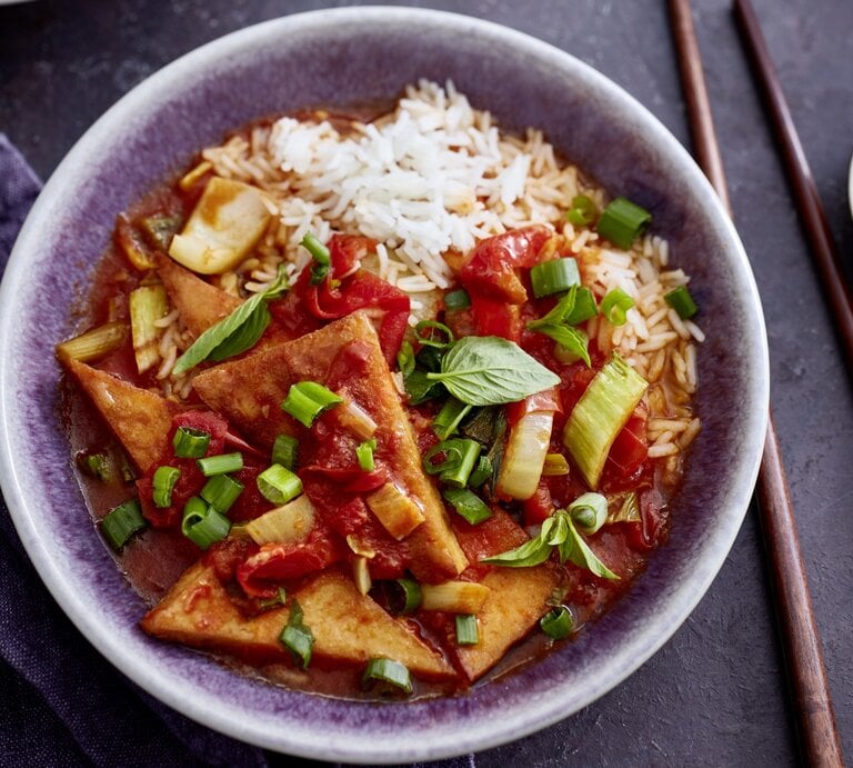 Tofu süßsauer mit Pak Choi und Paprika in einer grauen Schüssel auf grauem Hintergrund. Rechts von der Bowl sind Stäbchen.  | © EAT CLUB/Isabell Triemer