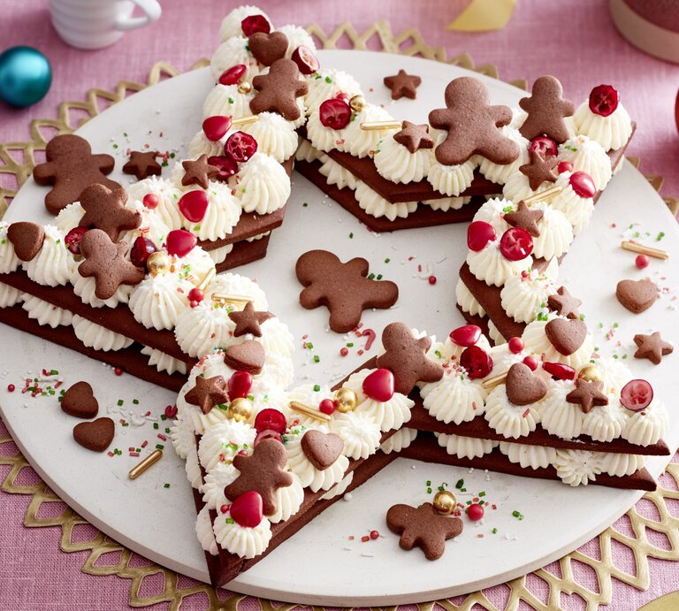 Lebkuchenstern-Torte auf einem weißen Tortenteller auf rosa Hintergrund. | © EAT CLUB / Isabell Triemer