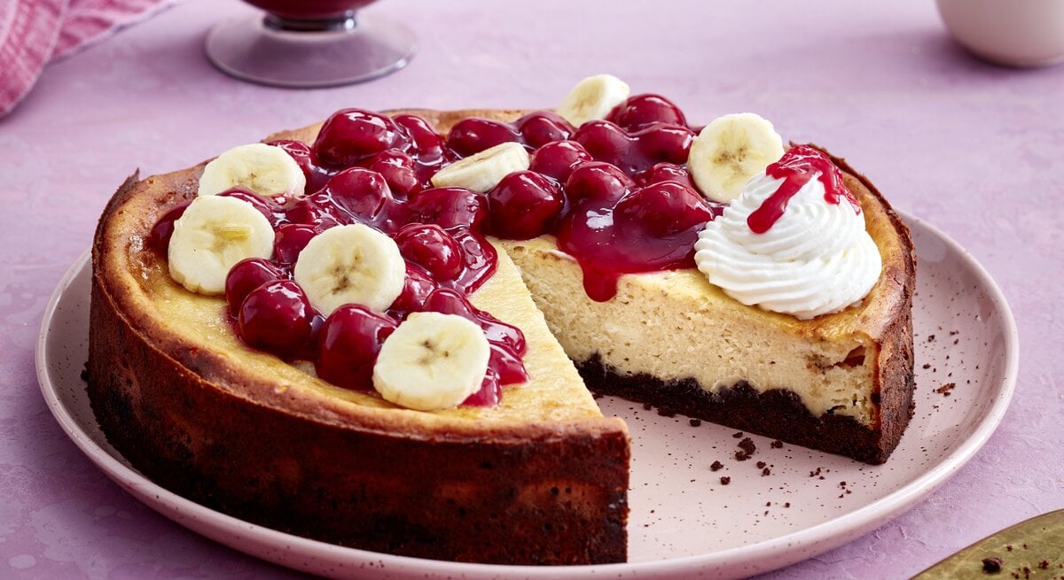 KiBa-Cheesecake auf einem rosa-farbenen Teller auf rosa Hintergrund. 