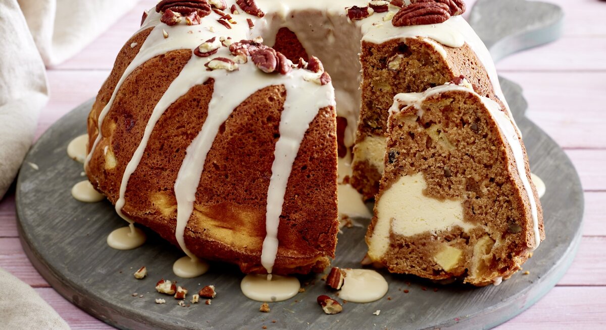 Apfel-Gugel mit Cheesecake-Füllung auf einem grauen Tortenteller auf rosa Hintergrund.