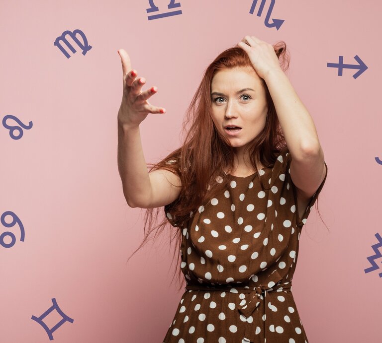 Eine Frau rauft sich die Haare und ist umgeben von einem Tierkreis mit den astrologischen Symbolen der Sternzeichen. | © phkorotkova und Chikovnaya via Canva.com [M]