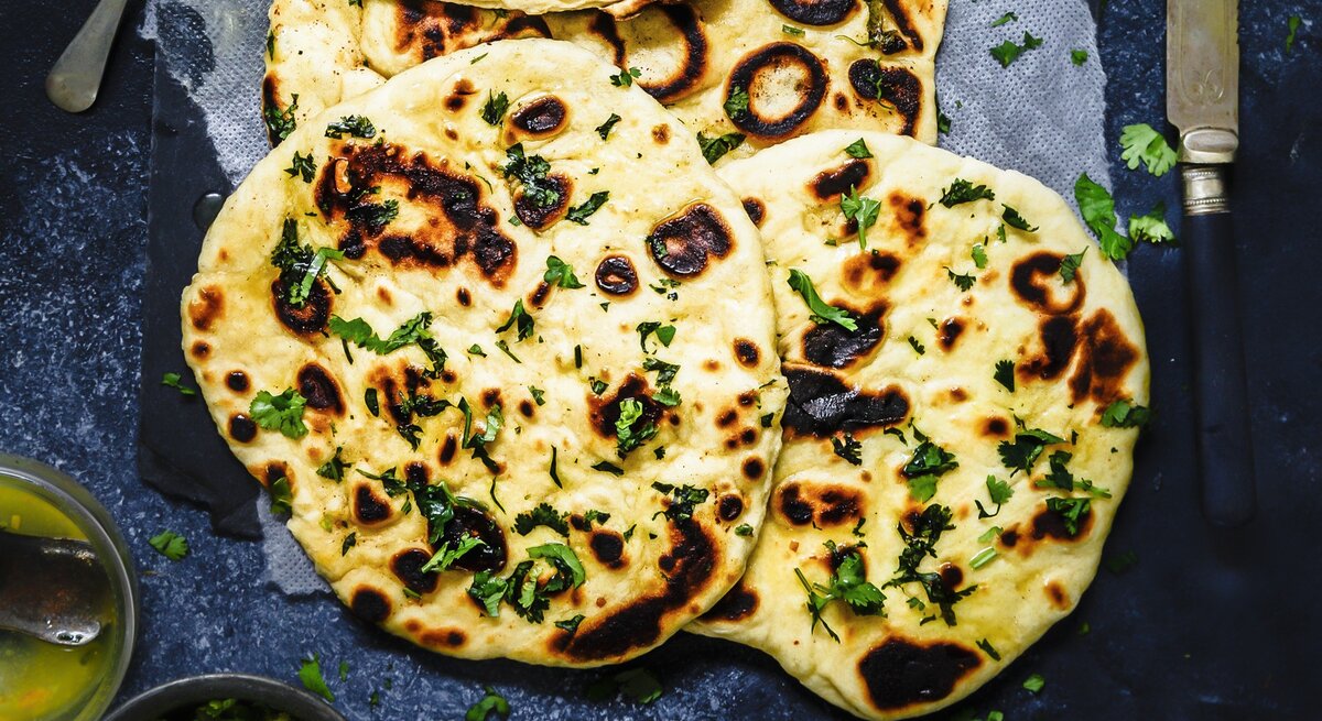 Runde Naan-Brote mit Knoblauchbutter und Käse / Draufsicht