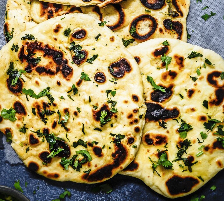 Runde Naan-Brote mit Knoblauchbutter und Käse / Draufsicht | © Stockfood/The Picture Pantry