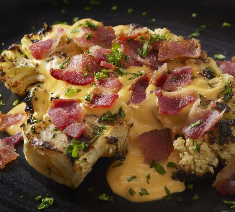 Blumenkohl-Steak mit Käsesoße und Schinken. | © GettyImages/LauriPatterson