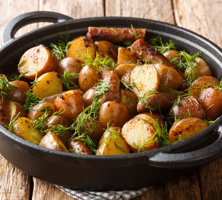 Seitliche Ansicht von einer Kartoffelpfanne mit Würstchen. | © Getty Images/ALLEKO