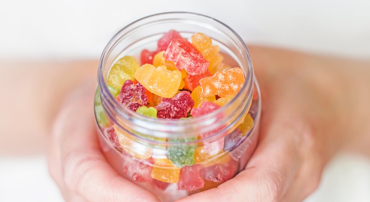 Hand mit Gummibärchen für Gummibärchen-Diät